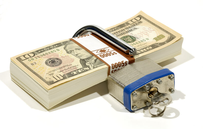 A padlock resting on currency, representing financial security